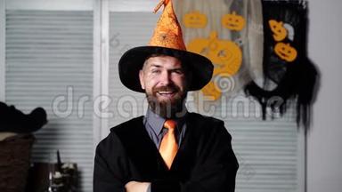 万圣节派对和滑稽的巫师。 万圣节背景。 神奇的帽子。 戴着橙色帽子的蓄胡子男人扬起眉毛，